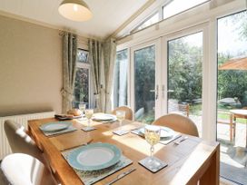 A dining room with a table set for meals at Oak Lodge Battisford near Stowmarket