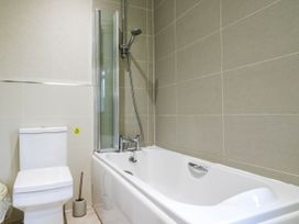 A bathroom with a bathtub and toilet at Oak Lodge in Battisford near Stowmarket