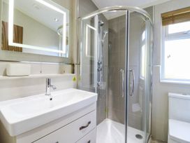 A bathroom with a shower, sink, and toilet at Oak Lodge Battisford near Stowmarket