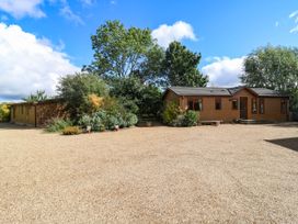 A house with gravel driveway and trees at Oak Lodge Battisford near Stowmarket