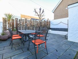 An outdoor dining area with a table and chairs at Bryn Tirion - Rhosneigr