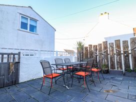 An outdoor dining area with a table and chairs at Bryn Tirion - Rhosneigr