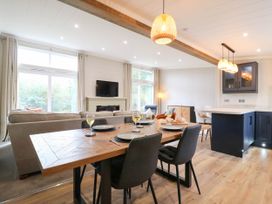 A dining table with chairs in a living room and dining area at Cherry Lodge Battisford near Stowmarket