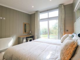A bedroom with two beds and a desk at Cherry Lodge in Battisford near Stowmarket