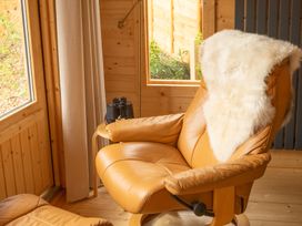 A snug with a chair and binoculars at Willow Lodge Stowmarket