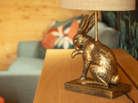 A lamp shaped like a rabbit on a wooden table at Willow Lodge in Stowmarket