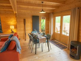 A dining room with a table and chairs at Willow Lodge in Stowmarket