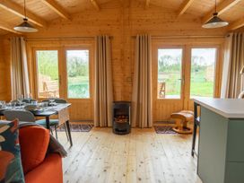 A living room with a dining table and chairs at Willow Lodge in Stowmarket