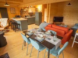 A living room with a dining area and kitchen at Willow Lodge in Stowmarket