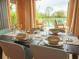 A dining room setup with plates and glasses at Willow Lodge in Stowmarket