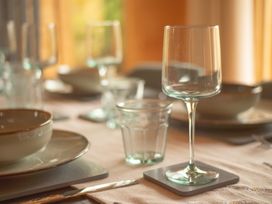 A dining room table set with plates and glasses at Willow Lodge Stowmarket