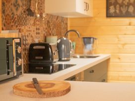 A kitchen with a cutting board and appliances at Willow Lodge in Stowmarket