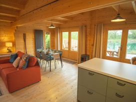 A living room with a sofa and dining area at Willow Lodge in Stowmarket