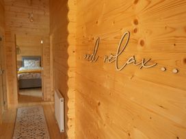 A hallway with wooden walls and a bedroom visible at Willow Lodge in Stowmarket