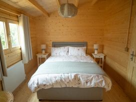 A bedroom with a bed and nightstands at Willow Lodge in Stowmarket