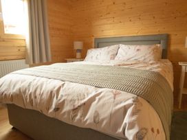 A bedroom with a bed and bedside table at Willow Lodge Stowmarket