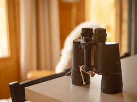 A pair of binoculars on a table at Willow Lodge in Stowmarket
