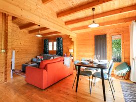 A living room with a sofa and dining table at Willow Lodge in Stowmarket