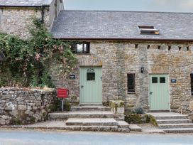 An outdoor view of a stone building with green doors at Brimble Cottage at Dockwell Farm, Newton Abbot