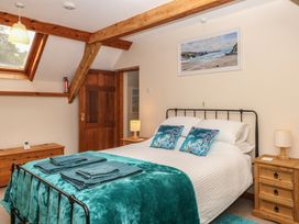 A bedroom with a bed and side tables at Brimble Cottage at Dockwell Farm Newton Abbot
