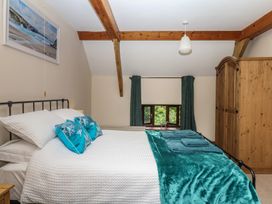 A bedroom with a bed and wardrobe at Brimble Cottage at Dockwell Farm, Newton Abbot