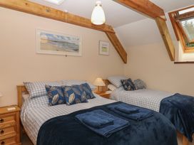 A bedroom with two beds and a bedside table at Brimble Cottage at Dockwell Farm in Newton Abbot