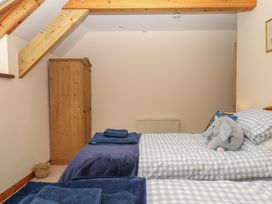 A bedroom with two beds and a wardrobe at Brimble Cottage at Dockwell Farm Newton Abbot