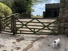 A gated entrance with a dog walking at Brimble Cottage at Dockwell Farm near Widecombe-In-The-Moor
