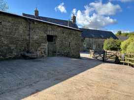An outdoor area with stone buildings and a gate at Brimble Cottage at Dockwell Farm near Widecombe-In-The-Moor
