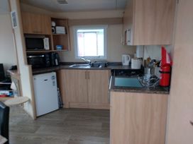 A kitchen with cabinets and appliances at Golden Sands FSB38 in Rhyl