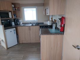 A kitchen with appliances including a refrigerator and stove at Golden Sands FSB38 Rhyl