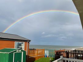 A view of a rainbow over the sea with a shed and decking at Golden Sands FSB38 Rhyl