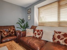 A living room with leather sofa and cushions at 1 Grenville Road in Truro