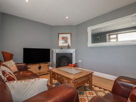 A living room with a television and a coffee table at 1 Grenville Road in Truro