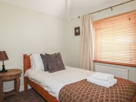 A bedroom with a bed and side table at 1 Grenville Road in Truro
