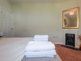 A bedroom with towels stacked on a bed at 1 Grenville Road in Truro