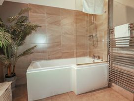 A bathroom with a bathtub and a shower at 1 Grenville Road in Truro