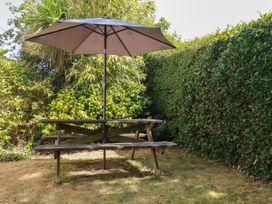 A table with an umbrella in a garden at 1 Grenville Road Truro