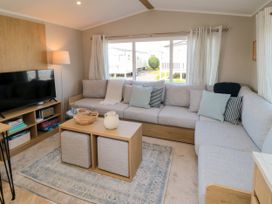 A living room with a sofa and television at 5 Rowen Court in Scarborough