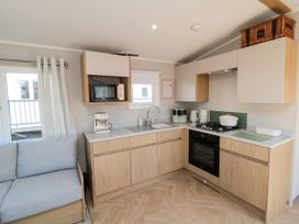 A kitchen with appliances and a sofa at 5 Rowen Court in Scarborough