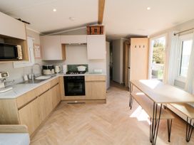 A kitchen with appliances and a dining table at 5 Rowen Court Scarborough