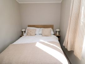 A bedroom with a bed and bedside lamp at 5 Rowen Court Scarborough