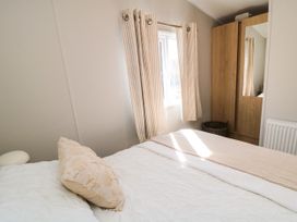 A bedroom with a bed and wardrobe at 5 Rowen Court in Scarborough