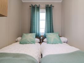 A bedroom with two beds and curtains at 5 Rowen Court in Scarborough