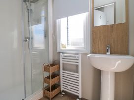 A bathroom with a shower and washbasin at 5 Rowen Court in Scarborough