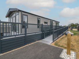 A mobile home with a deck and pathway at Lodge 1 St. Osyth