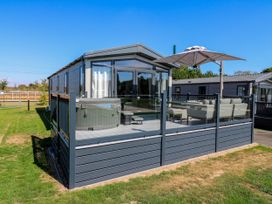 A patio with hot tub and seating area at Lakewood Plot 1 St. Osyth