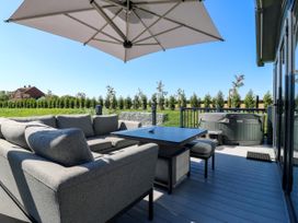 An outdoor seating area with a sofa and hot tub at Lakewood Plot 1 St. Osyth