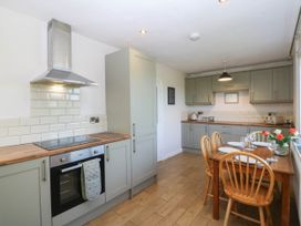 A kitchen with appliances and dining table at Wilpol in Llanerchymedd
