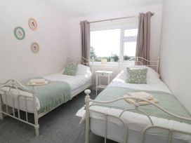 A bedroom with two beds and a window at Wilpol in Llanerchymedd